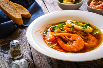Seafood soup on wooden table
