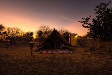 Camping in the wilderness. A pitched tent under the glowing sunset sky, Laikipia, Kenya.	