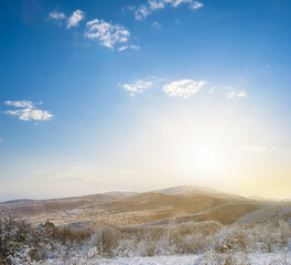 winter snowbound mountain valley in dense clouds at the sunset