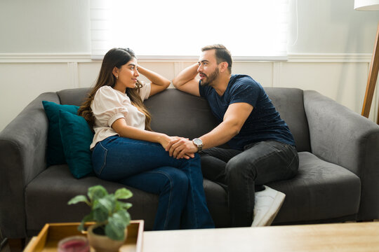 Beautiful couple talking while relaxing on the sofa