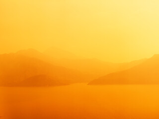 Aerial view Lantau Island and the South China Sea on a smoggy orange sunset.