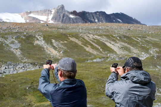 Two men using compasses on Jonas Pass in Jasper NP, Alberta, Canada.