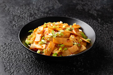 Spicy bamboo shoot salad in black bowl. Asian food