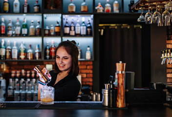 young woman bartender Making Cocktail in bar