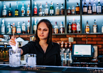young woman bartender Making Cocktail in bar