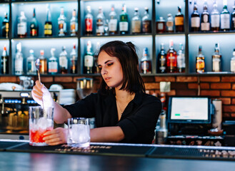 young woman bartender Making Cocktail in bar