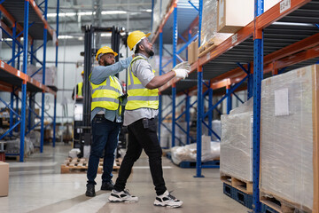 African american working in warehouse hold stock check list while truck loading carton box near by