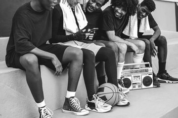 Group of young african people listening music outdoor after basketball match - Focus on ball -...