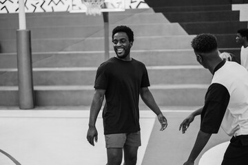 African friends playing basketball outdoor - Focus on. center man face - Black and white editing