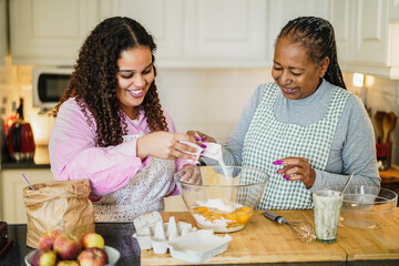 African mother and daughter preparing fruit cake at home - Soft focus on girl face