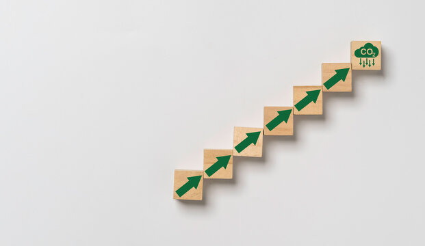 CO2 reducing icon with up arrow on wooden block cube for enhance decrease CO2 , carbon footprint and carbon credit to limit global warming from climate change, Bio Circular Green Economy concept.