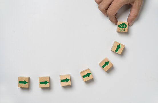 CO2 reducing icon with up arrow on wooden block cube for enhance decrease CO2 , carbon footprint and carbon credit to limit global warming from climate change, Bio Circular Green Economy concept.