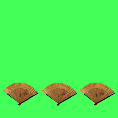 Three wooden an elegant fans with fine patterns on an green background.. Flat lay concept.