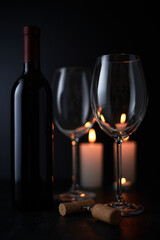 Elegant red wine glass and a wine bottle in black background