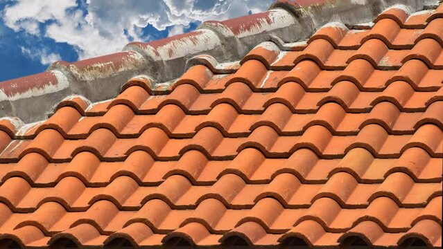 clay tile roof. the top cover of a brownish yellow new house building with a clear sky background during the day. dramatic cloud movement