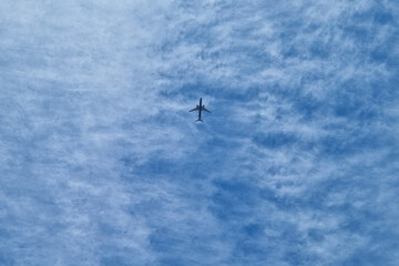The flight of the plane against the background of the blue sky. Fast and safe transport. Migration.