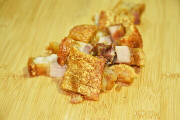 slice crispy pork on wooden chop block
