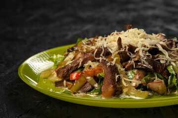 beef salad with vegetables on black background