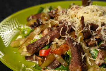 beef salad with vegetables on black background