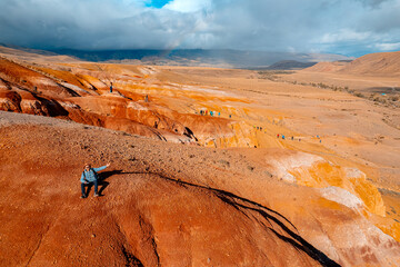 Tourist traveler on Altai landscape republic Russia. Red color sand and clay Mars Altay, Aerial...