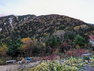Fototapeta na wymiar In front of Kosumo Hut in October, colored Mt. Kosumo. Okuwa Village, Nagano Prefecture, Japan