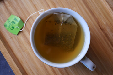 green tea and tea bag on table, close up.