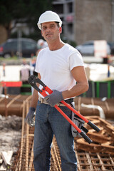 workman holding metal pliers tool at site