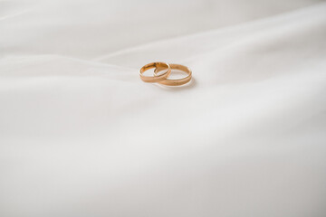 gold rings lie on a white veil