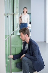 Fototapeta premium male student opening a locker at college