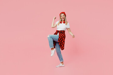 Full body happy young woman wear white t-shirt red hat doing winner gesture celebrate clenching fists say yes isolated on plain pastel light pink background studio portrait. People lifestyle concept.