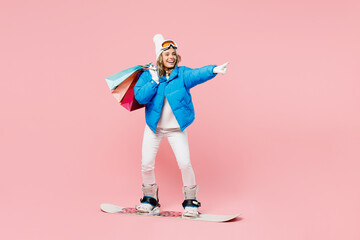Snowboarder woman wear blue suit goggles mask hat ski jacket hold package bags after shopping...