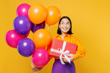 Happy fun smiling amazed young woman wear casual clothes celebrating look at balloons holding...