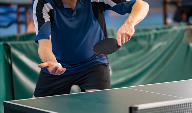 Table Tennis Player serving, holding ball in hand - Powered by Adobe