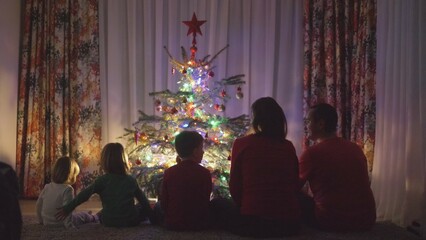 Fototapeta na wymiar Silhouette of big family in front of Christmas tree enjoy colorful lights