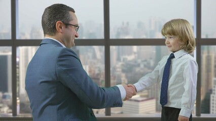 Father and son shaking hands at the office like businessmen