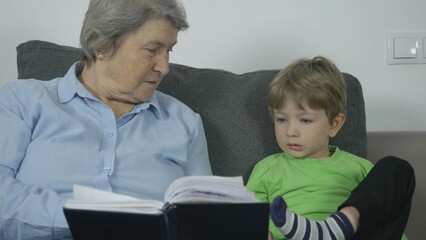 Elderly woman and little kid talking about a story from book