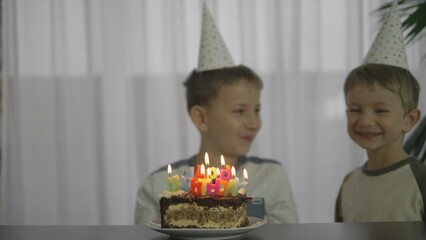 Obraz na płótnie Canvas Children blowing candles from birthday cake