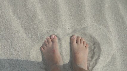 Man feet stepping on fine sand of the beach, enjoy summer vacation feeling