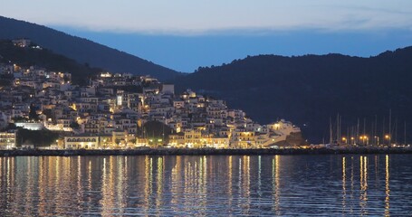 Beautiful Greece Skopleos town reflected in sea water, magical night landscape