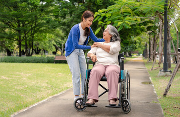 Fototapeta premium Asian careful caregiver or nurse taking care of the patient in a wheelchair. Concept of happy retirement with care from a caregiver and Savings and senior health insurance, a Happy family