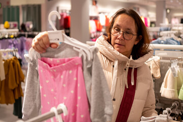 Frau beim Einkauf von Kinderkleidung
