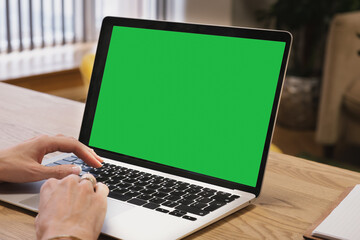 Green screen, copyspace and chromakey on a laptop of a business person typing. Laptop on the desk in the office. Template for inserting an image on the laptop screen.