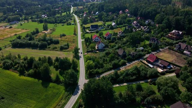 Aerial view of countryside road with moving cars, Weekend road trip to suburban area, Beatiful nature background with mountains and small village