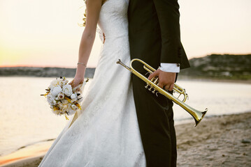 Wedding couple holding bouquet and trumpet