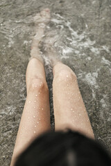 Female legs by the sea