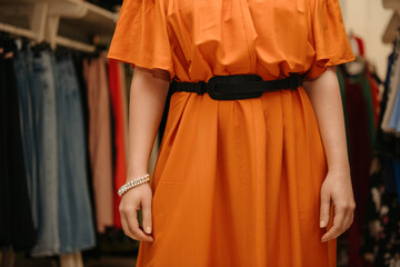 Woman in orange dress in clothing store