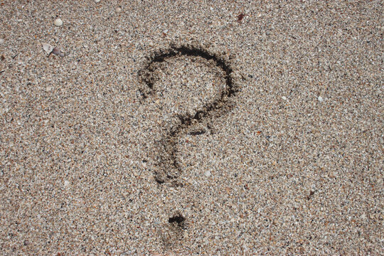 question mark on beach sand