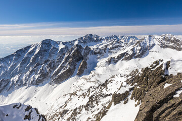 Fototapeta na wymiar Snowy winter high mountain landscape. A panoramic view from the top of The Lomnicky peak in High Tatras National Park, Slovakia, Europe.