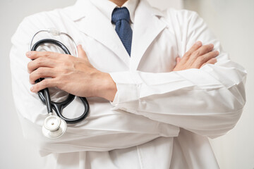 Portrait of Asian Doctor in glasses holding stethoscope isolated on white background