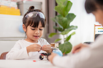 Asia students learn at home in coding robot cars and electronic board cables in STEM, STEAM, mathematics engineering science technology computer code in robotics for kids concept.